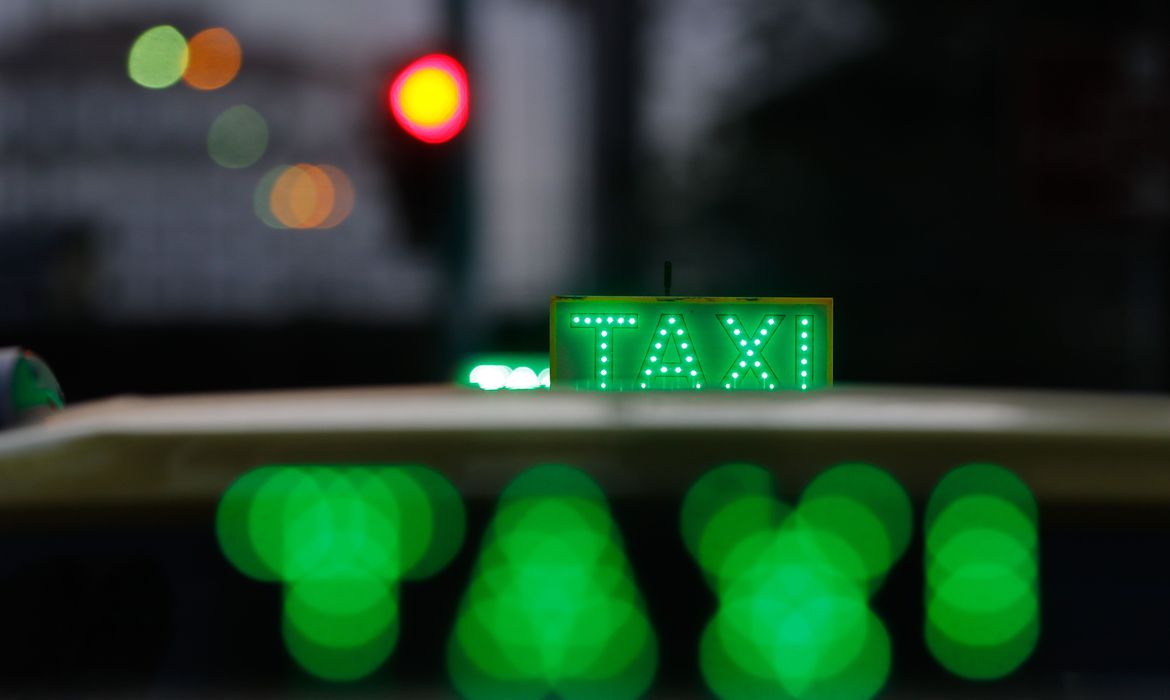 Cerca de 325 mil taxistas foram cadastrados pelas prefeituras para receber o benefício emergencial Bem-Taxista. Deste total, 290 mil não possuem pendências, o que os coloca como habilitados para receber essa compensação concedida até dezembro, com o objetivo de amenizar os efeitos do alto preço de combustíveis e derivados para esses profissionais. Os números, ainda não fechados, foram apresentados hoje (15) pelo ministro do Trabalho e Previdência, José Carlos Oliveira, em coletiva para esclarecer eventuais dúvidas sobre este benefício e sobre o Auxílio Caminhoneiro, concedido pelo mesmo motivo a motoristas autônomos. No caso dos transportadores autônomos, o governo trabalha tendo como referência a base de dados da Agência Nacional de Transporte Terrestre (ANTT), segundo a qual há, no país, pouco mais de 848,3 mil caminhoneiros. “Temos R$ 7,4 bilhões disponibilizados para os dois benefícios. Nossa intenção é a de usar todos esses recursos”, disse o ministro. Ele lembrou que, caso não sejam usados no prazo de 90 dias, os recursos “voltam para o Tesouro”. O valor mensal máximo dos dois benefícios é de R$ 1 mil. O ministro lembrou que esse valor pode ser reduzido, caso a demanda seja maior do que a projetada, de forma a ultrapassar o limite orçamentário de R$ 7,4 bilhões. “O valor teto é R$ 1 mil, mas pode reduzir caso haja um boom de taxistas inscritos, por exemplo”, disse Oliveira. Ele acrescentou que, pelo mesmo motivo, é possível também a redução do número de parcelas previstas. O ministro comentou que houve casos de prefeituras que não enviaram o cadastro de taxistas “por questões ideológicas”. “Não foi uma coisa alarmante, mas aconteceu”, ponderou sem detalhar quais teriam sido essas prefeituras. Taxistas O auxílio emergencial voltado a taxistas começará a ser pago amanhã (16) em seis parcelas de R$ 1 mil, “observadas a quantidade de taxistas elegíveis e o limite global disponível para o pagamento do auxílio”, conforme informado pelo Ministério do Trabalho. As parcelas de julho e agosto serão pagas juntas, e a terceira parcela será paga em 30 de agosto. Têm direito ao benefício motoristas de táxi registrados nas prefeituras, titulares de concessões ou alvarás expedidos até 31 de maio. Segundo o ministro, as prefeituras terão muitas oportunidades para atualizarem o cadastro, de forma a garantir que os beneficiários acessem seus direitos. “Sempre vamos permitir que os prefeitos complementem a informação”, garantiu Oliveira. O motorista que estiver com o CPF pendente de regularização junto à Receita Federal não poderá receber o valor. Além disso, o benefício não poderá ser pago cumulativamente com o auxílio caminhoneiro. Mais informações podem ser obtidas por meio do aplicativo Caixa Tem. Caminhoneiros Os motoristas de carga autônomos receberam, no dia 9, as duas primeiras parcelas do Auxílio Caminhoneiro. O dinheiro foi depositado nas contas poupança sociais digitais, mas podem ser movimentado por meio do aplicativo Caixa Tem, que permite a compra em lojas virtuais cadastradas, o pagamento de contas domésticas e a transferência para qualquer conta bancária. Criado pela emenda constitucional que estabeleceu estado de emergência por causa da alta do preço dos combustíveis, o Auxílio Caminhoneiro será concedido até dezembro para os profissionais cadastrados no Registro Nacional de Transportadores Rodoviários de Cargas (RNTR-C), da ANTT até 31 de maio deste ano. Também chamado de Benefício Emergencial Caminhoneiro (Bem-Caminhoneiro), o auxílio será pago a cada transportador autônomo, independentemente da quantidade de veículos que tiver. O pagamento será revisado mensalmente. Para os próximos lotes de pagamento, a ANTT vai encaminhar ao Ministério do Trabalho e Previdência a relação dos transportadores autônomos de cargas que estiverem na situação “ativo” no RNTR-C. Quem estiver com situação cadastral pendente ou suspensa poderá regularizar o registro na ANTT e receber as parcelas a partir da data da regularização. No entanto, o governo esclarece que não terá direito a parcelas que tenham sido pagas.